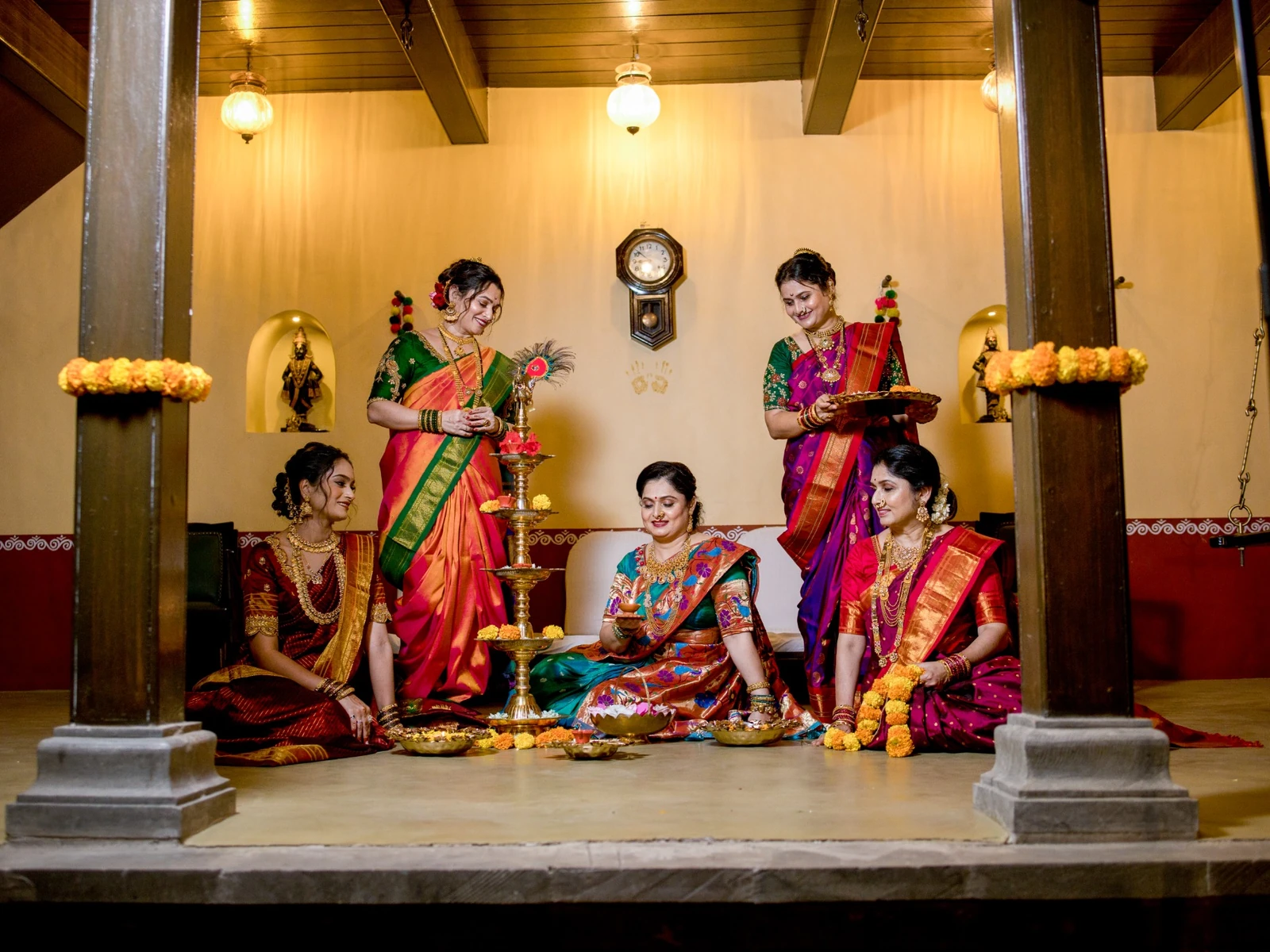 Celebration in the diwankhana under warm pendant lanterns with a tall brass samai lamp.