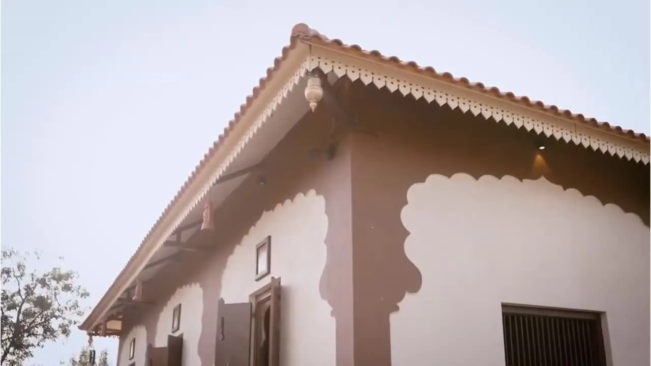 The verandah arcade at Gundal Wada, its cusped arches and tiled roofline in low light.